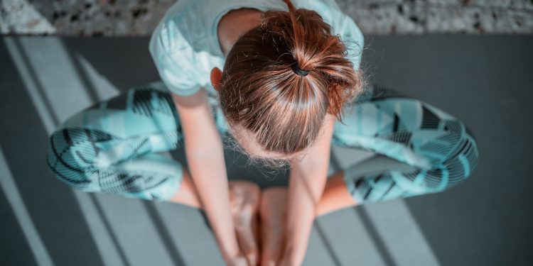 girl in teal t-shirt lying on white and black stripe bed